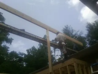 Carpenter setting a ridge beam over a new addition frame — Ice Dam Removal by Roofing Brothers in Gillette