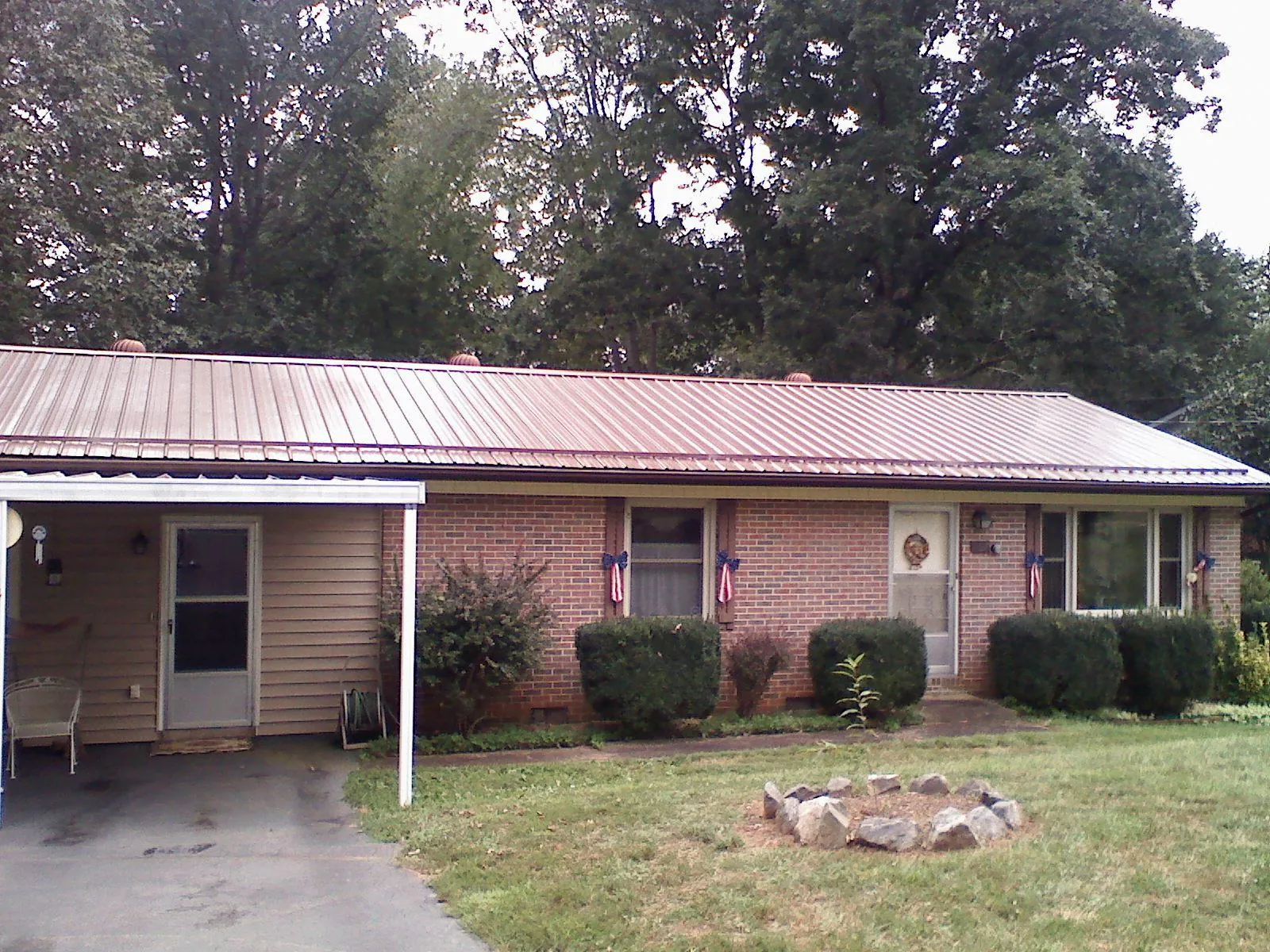 Bronze metal roof and carport on a brick ranch home — Roof Repair work by our crew in Gillette